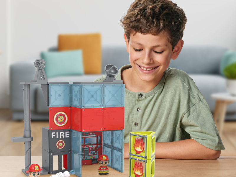 Boy playing with his Tile Town Fire station Playset.