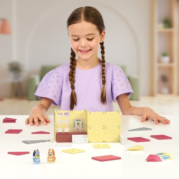 Girl assembling her Tile Town Bluey Heeler Family Home Play set.