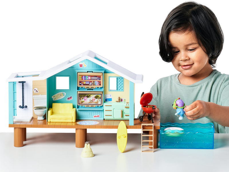 Young boy playing with Bluey beach house set.